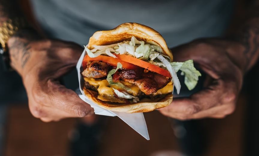 person holding a burger from a fast-food chain