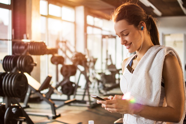 girl with smartphone in a gym